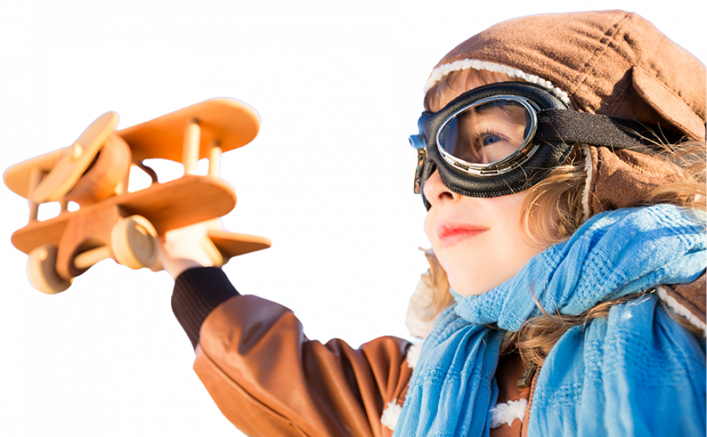 Child in pilot outfit with toy wooden airplane